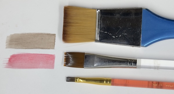 Three flat synthetic watercolour brushes of varying widths, shown alongside two smooth swatches of colour (one beige, one pink) demonstrating their use for even washes and clean edges.