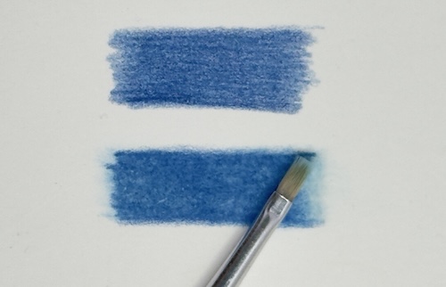 Demonstrating solvent blending: a brush applies liquid solvent to smooth coloured pencil, comparing unblended (top) and blended (bottom) areas