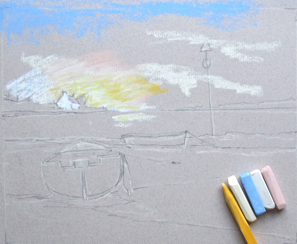 Lightest sky colours blocked loosely over the top of the pastel drawing, with pastel sticks alongside