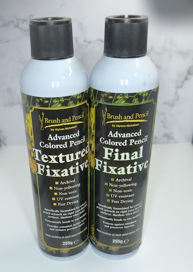 Two aerosol cans of Brush and Pencil fixatives: Advanced Colored Pencil Textured Fixative and Advanced Colored Pencil Final Fixative.