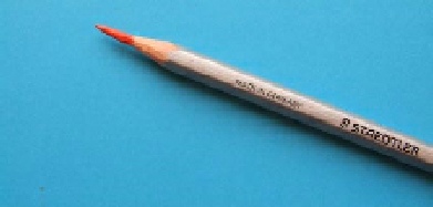 A Staedtler Karat Aquarell watercolour pencil with its wood casing whittled back to expose a long pigment core, demonstrating a knife-sharpened point.