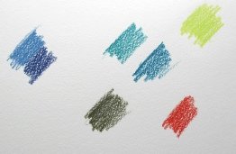 A piece of white card used as a palette for watercolour pencil pigment