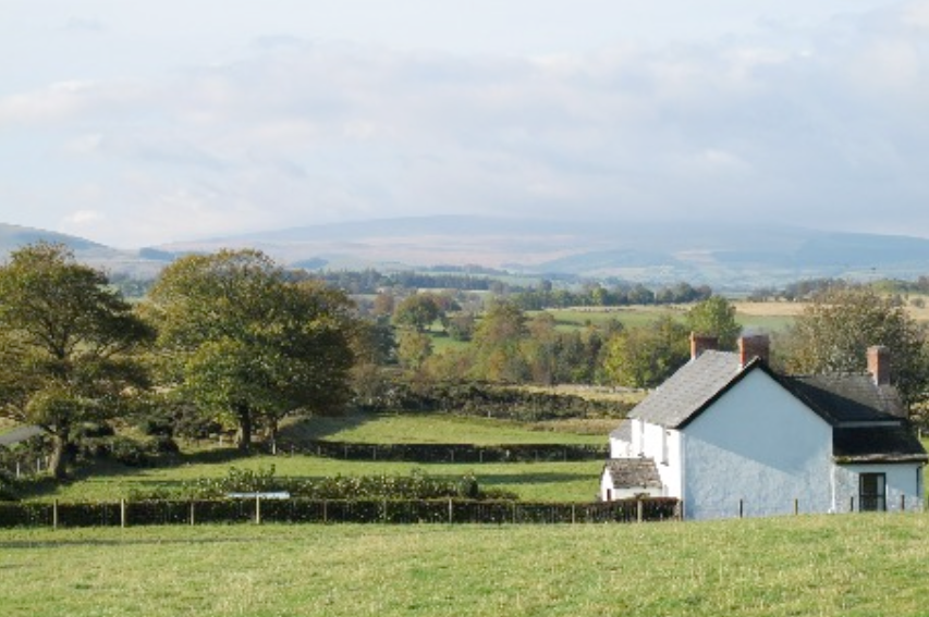 Reference photo of a white farmhouse in the Brecon Beacons near Pen y Fan with hills behind
