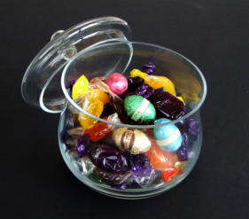 Reference photo of a glass jar of wrapped sweets on black mount board